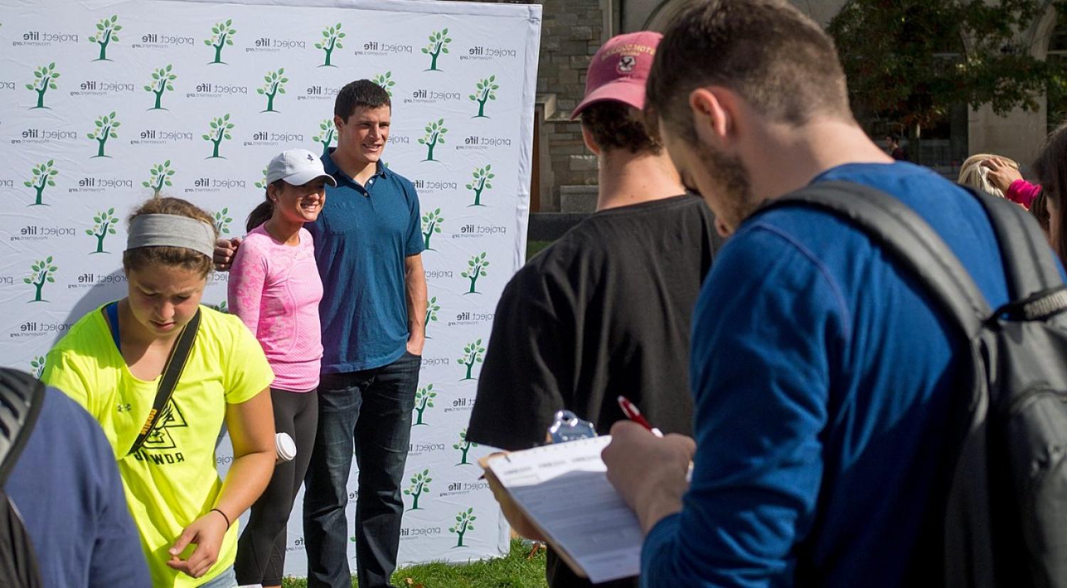 Luke Kuechly posing for photos with students